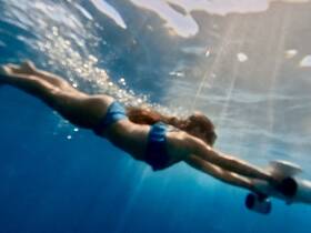 A swimmer glides gracefully underwater, showcasing the beauty of aquatic adventures — perfect for snorkeling or diving experiences.