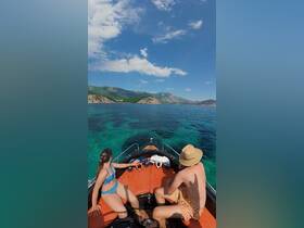 A couple enjoys a scenic boat ride over crystal-clear waters, perfect for summer adventures and exploring beautiful coastlines.