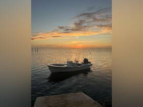 A serene sunset view of a fishing boat docked on calm waters, perfect for a tranquil evening on the water.