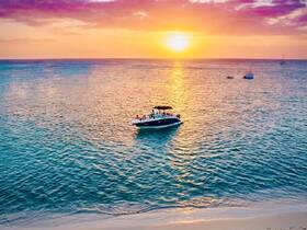 A stunning sunset view with a boat cruising on tranquil waters, creating the perfect backdrop for memorable on-water experiences.
