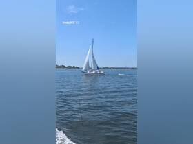 A beautiful sailboat glides through the water, showcasing its sails against a clear blue sky — perfect for sailing enthusiasts and adventure seekers.
