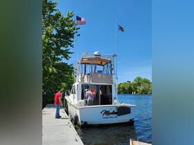 Two individuals prepare the boat named 'Madison' at the dock, showcasing a beautiful day on the water — perfect for fishing or leisure outings.