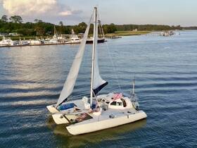 A catamaran anchored near the dock with guests relaxing on the deck, showcasing a perfect day for sailing and leisure on the water.
