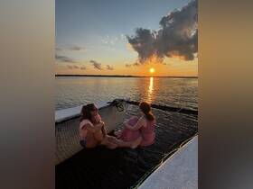 Two friends enjoy a serene sunset on a boat, creating a perfect backdrop for relaxation and memorable moments on the water.