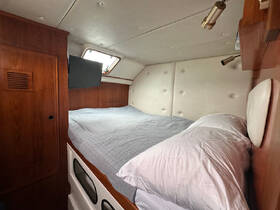 Cozy cabin interior featuring a comfortable bed and modern amenities, perfect for relaxing on a boat getaway.