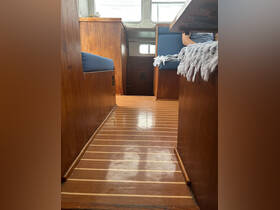 A cozy interior view of a boat cabin featuring wooden flooring and seating areas, perfect for relaxing during a day on the water.
