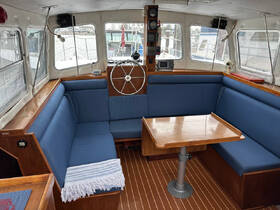 Cozy interior of a boat featuring comfortable seating and a helm, perfect for relaxing during a day on the water.