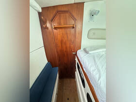 Interior view of a cozy boat cabin featuring a seating area and storage, ideal for relaxation during trips on the water.