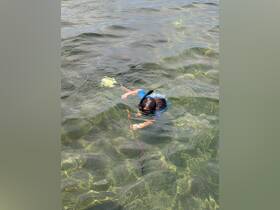 A child enjoys snorkeling in clear waters, exploring the underwater world — a perfect activity for family adventures and marine exploration.