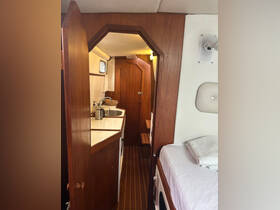 Interior view of a cozy boat cabin featuring a well-equipped galley and comfortable sleeping area, perfect for relaxing during a sailing trip.