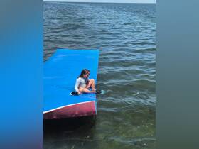A child enjoys a fun moment sitting on a floating mat in the water, equipped with snorkel gear — perfect for summer water activities and family adventures.