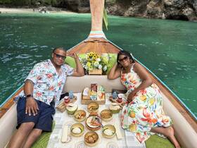 A couple enjoys a delightful meal on a boat surrounded by stunning tropical waters, perfect for romantic getaways or special celebrations.