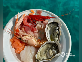 A vibrant seafood platter featuring shrimp, oysters, and sashimi, perfect for enjoying fresh flavors while on a boat trip.