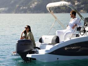A stylish couple enjoys a relaxing moment on a boat, surrounded by tranquil waters — perfect for romantic getaways or leisurely days on the sea.