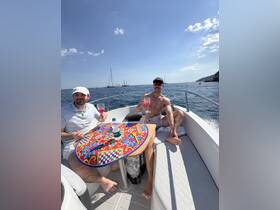 Two friends enjoy refreshing cocktails on a sunny boat trip, perfect for celebrating summer days on the water.