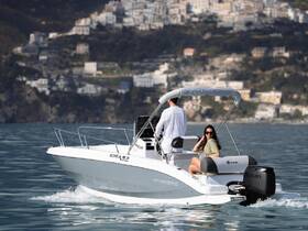 A couple enjoys a scenic cruise on a sleek boat, surrounded by stunning coastal views — perfect for a day on the water.