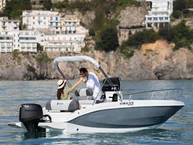 A couple enjoys a romantic moment on a sleek boat, surrounded by stunning coastal scenery — perfect for intimate getaways or special celebrations on the water.