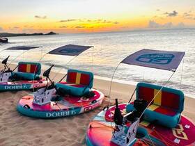 Colorful floating mats set up on the beach at sunset, perfect for relaxing and enjoying the serene coastal views.