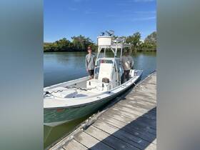 Two individuals pose on a fishing boat at the dock, ready for an exciting day on the water. Ideal for fishing trips or leisurely outings.