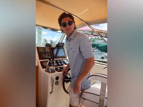 A young man stands at the helm of a boat, showcasing the detailed console and controls — perfect for navigating the waters.