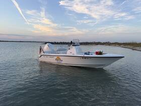 A sleek Key West speedboat is docked in calm waters, showcasing its design against a picturesque sky — perfect for a day of adventure on the water.