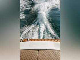 A stunning aerial view of a boat's wake as it glides through the water, showcasing the beauty of a day on the sea.