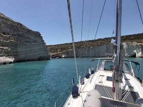 A stunning view of a sailboat navigating through crystal-clear waters, framed by dramatic cliffs — perfect for exploring scenic coastlines.
