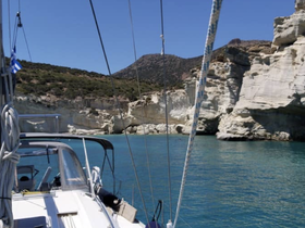 A picturesque view of a sailboat navigating through clear turquoise waters, with stunning cliffs in the background, perfect for exploring coastal landscapes.