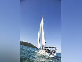 A beautiful sailboat glides through clear waters, showcasing its elegant sails against a bright blue sky — perfect for sailing adventures.