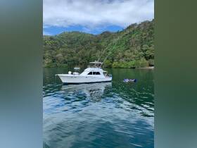 A group enjoys a relaxing day on the water, with a boat anchored nearby and some people swimming in the serene surroundings.