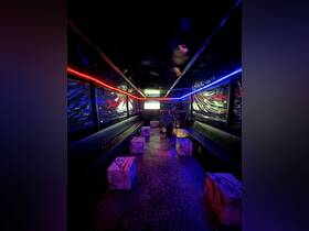 A vibrant interior view of a boat lounge area featuring stylish seating and colorful lighting, perfect for social gatherings and entertainment on the water.