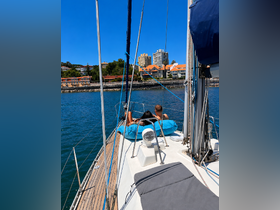 A couple relaxes on the deck of a yacht, enjoying the scenic waterfront views — a perfect moment for leisure on the water.
