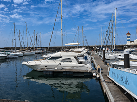 A stunning view of the 'Clara Vitoria' yacht docked at the Marina de Cascais, surrounded by a variety of other boats under a clear blue sky.