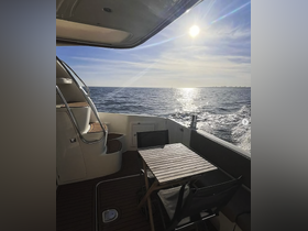 A serene view of the interior cabin of a boat, featuring a stylish seating area and a table, perfect for enjoying the scenic ocean views.