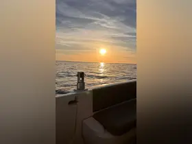 A serene sunset view from the deck of a boat, showcasing the tranquil ocean and vibrant sky — perfect for evening cruises.