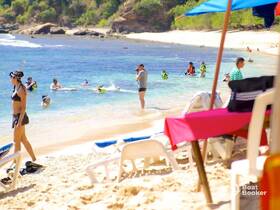 A vibrant beach scene with guests snorkeling and enjoying the water, showcasing a fun day of aquatic activities in a picturesque setting.