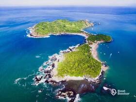 A stunning aerial view of a lush green island surrounded by vibrant blue waters, showcasing the perfect destination for beach lovers and nature enthusiasts.