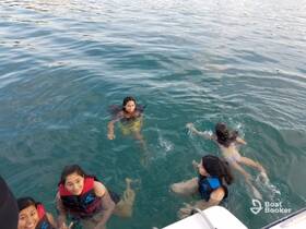 A group of young swimmers enjoy a fun day in the water, showcasing the excitement of aquatic adventures while wearing life jackets.
