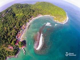 A stunning aerial view of a lush coastline and beach, showcasing the vibrant turquoise waters and scenic island landscape — perfect for exploring and relaxation.