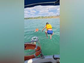 A child leaps off the boat into the water, showcasing a fun day of swimming and adventure. Perfect for family outings and water activities.