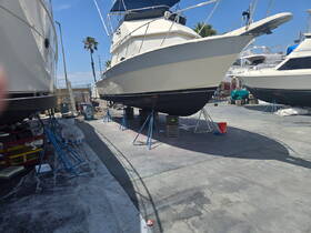 A view of multiple boats docked and lifted for maintenance, showcasing their hulls and structure in a marina setting.