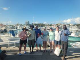 A cheerful group poses for a photo at the marina, celebrating their boating adventure — perfect for capturing memories of fun times on the water.