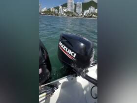 Close-up view of Suzuki outboard motors on a boat, with a backdrop of a coastal city. The image focuses on the motors, making it unclear for broader context.