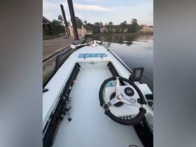 A detailed view of the helm and console area of a fishing boat, showcasing the steering wheel and fishing gear, perfect for anglers looking to navigate the waters.