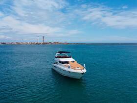 A stunning aerial view of a luxurious yacht docked in calm waters, showcasing its elegant design and inviting deck space — perfect for upscale boating experiences.