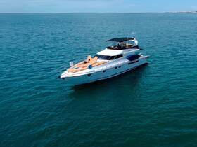 An aerial view of a luxurious yacht cruising through calm waters, showcasing its elegant design and spacious deck — perfect for upscale charters and leisurely outings.
