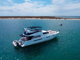 A stunning aerial view of a luxurious yacht anchored in calm waters, showcasing its sleek design and inviting deck — perfect for upscale boating experiences.