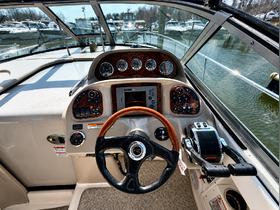 A detailed view of the helm and console inside a boat, showcasing the steering wheel and various controls — perfect for navigating the waters.