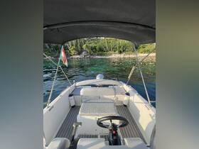 A view of the helm and seating area inside a boat, showcasing a clean and functional interior design, perfect for a day on the water.