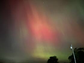 A captivating display of colorful lights in the night sky, possibly the aurora borealis, creating a stunning natural spectacle.